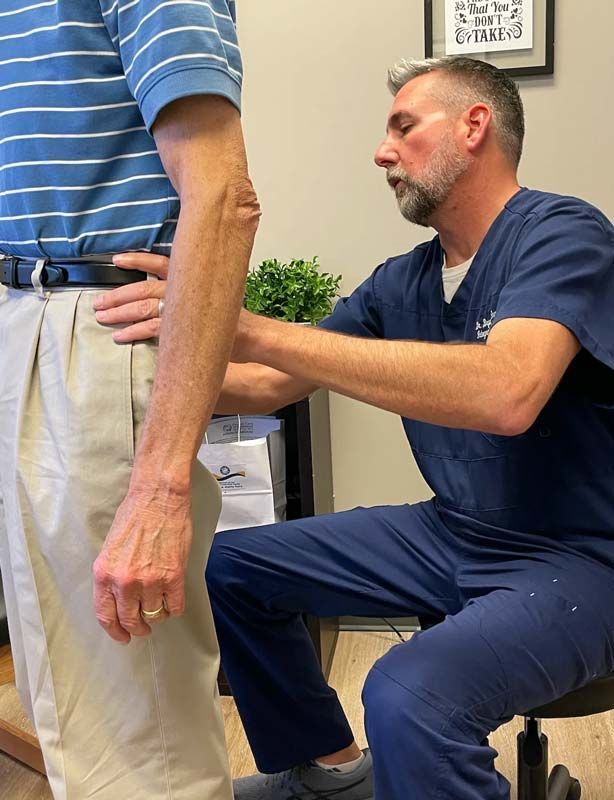 patient receiving back pain exam from doctor