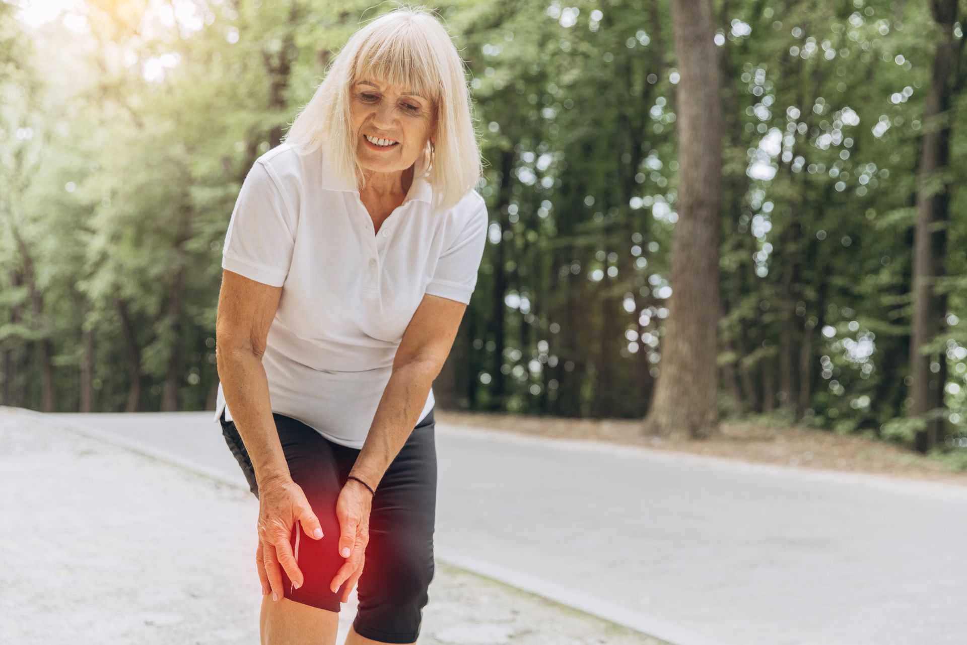 older woman holding her knee in pain