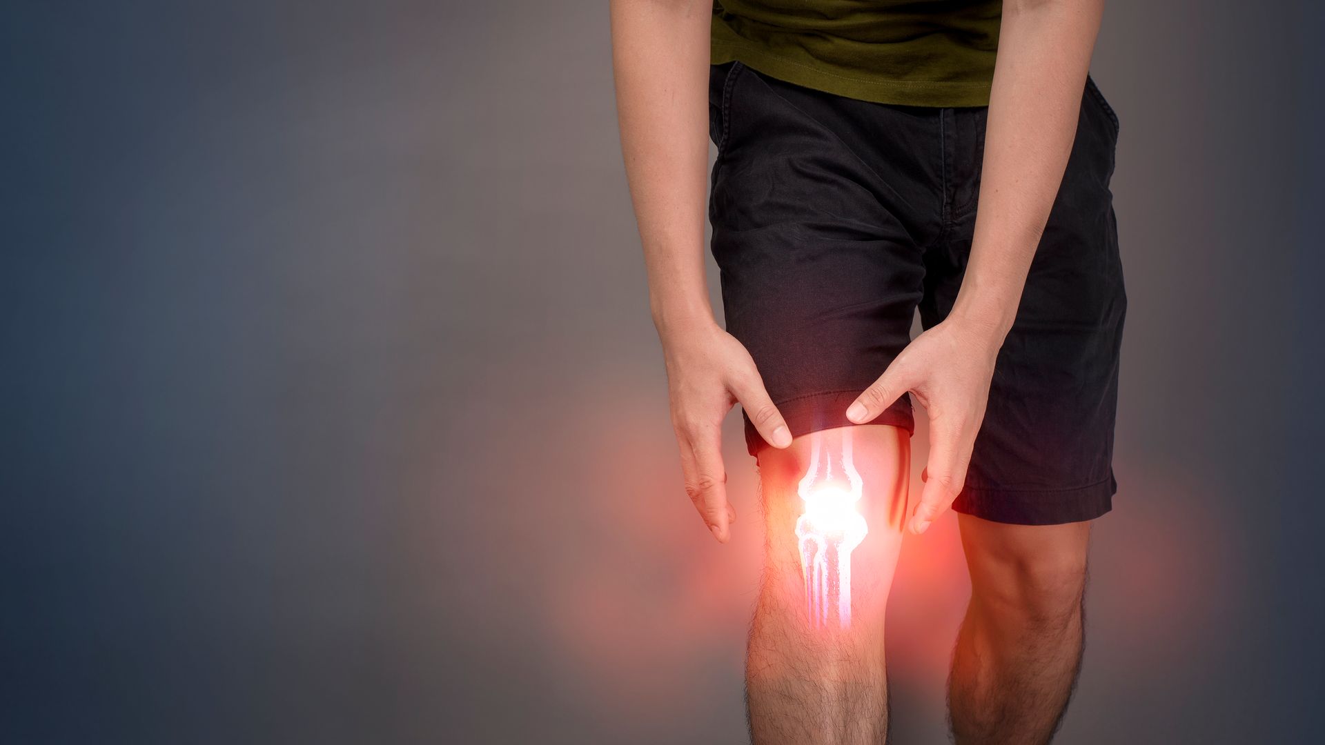 man holding inflamed knee in pain