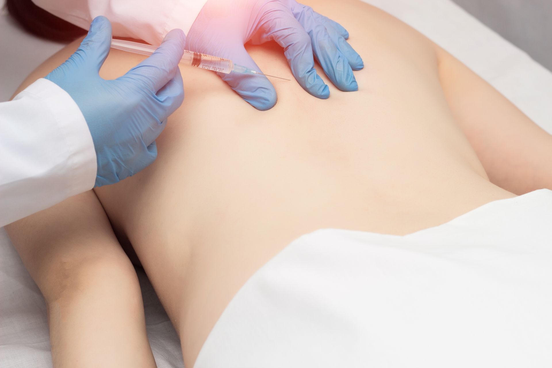 a doctor utilizing trigger point injections in a woman's back