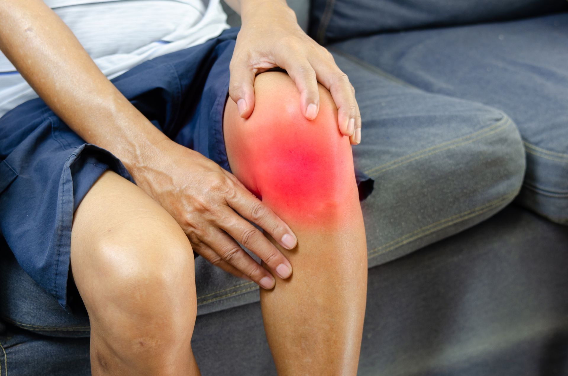 man holding inflamed knee in pain
