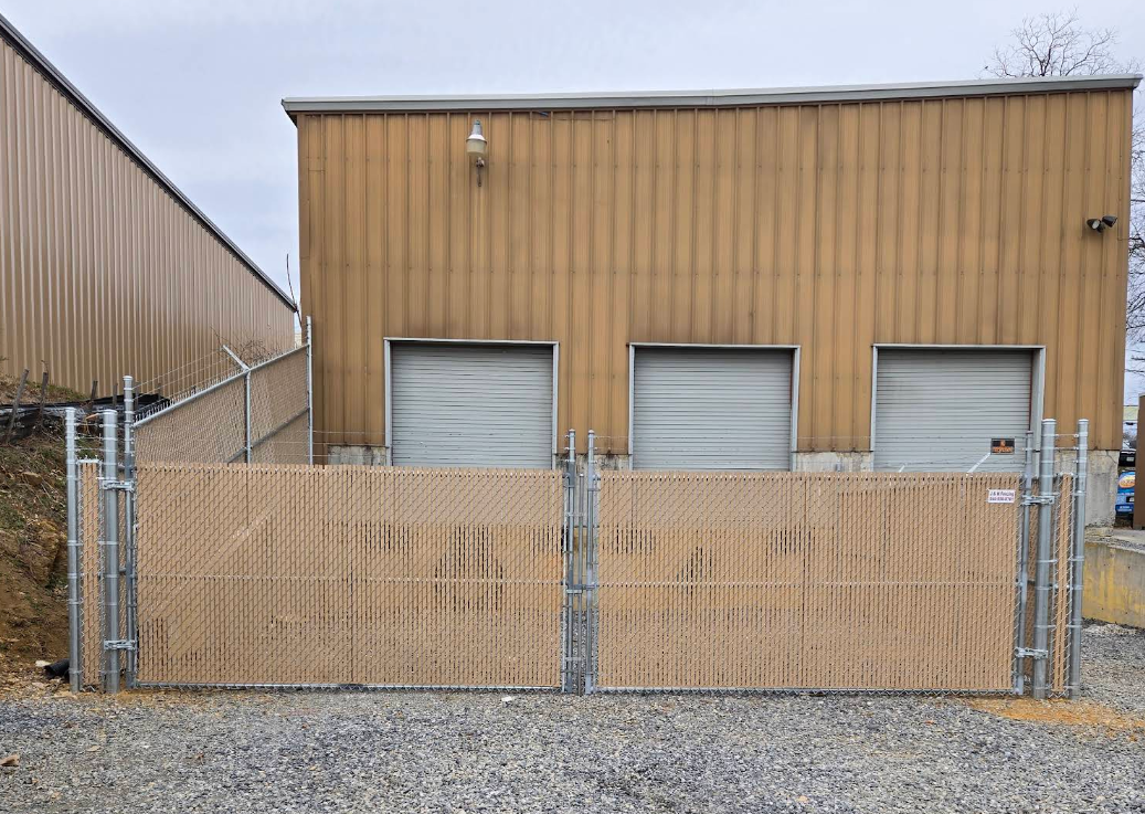 Commercial fence installation with privacy slats by a professional fence contractor in Boones Mill, securing a business loading dock area