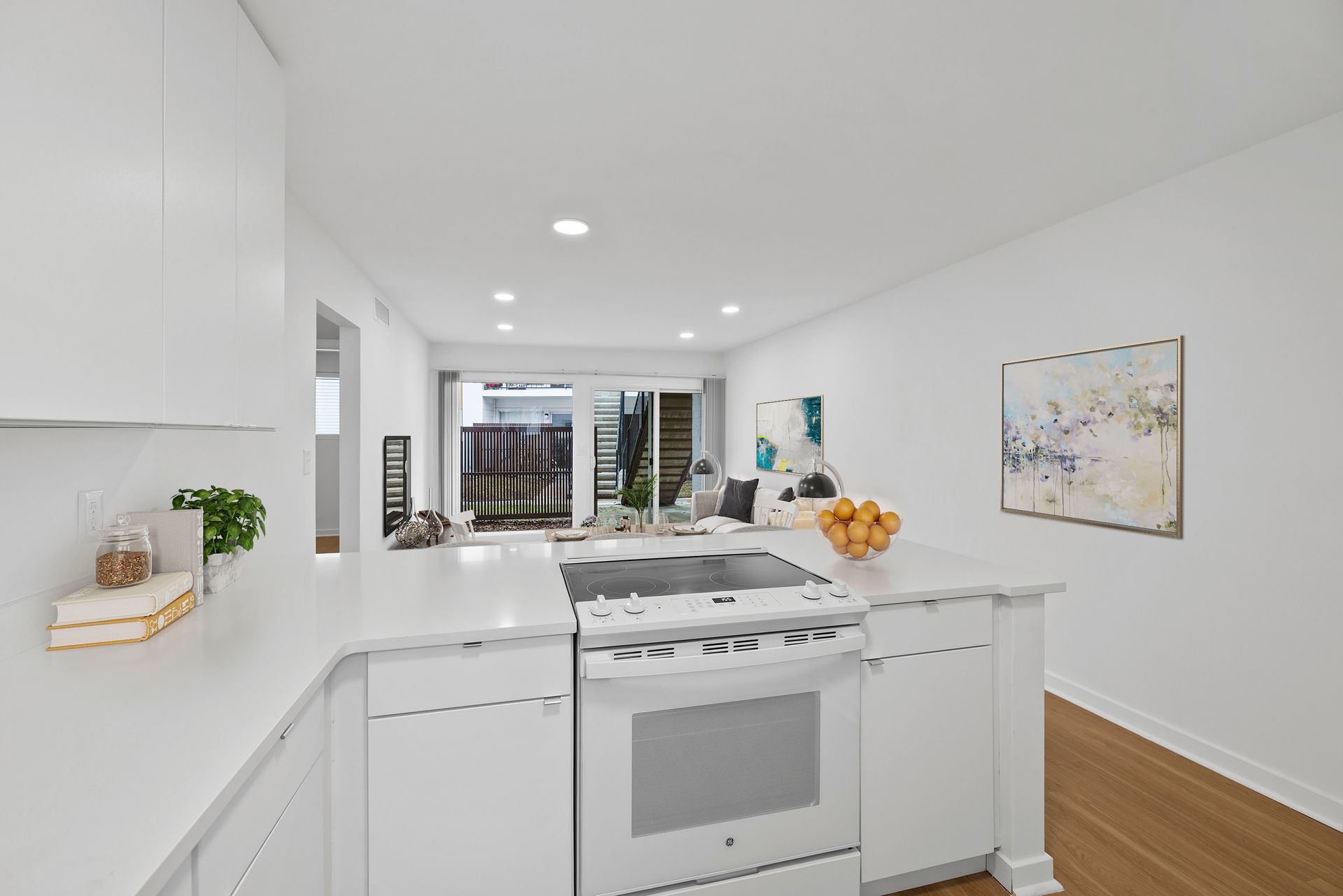 A kitchen with white cabinets , a stove , and a sink at The Hale Nani Apartments in Neptune Beach, Florida.