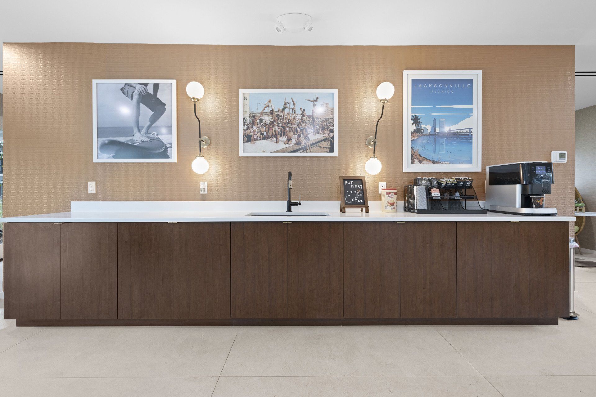 Hale Nani apartment clubhouse kitchen with wall art, sink, and coffee bar.