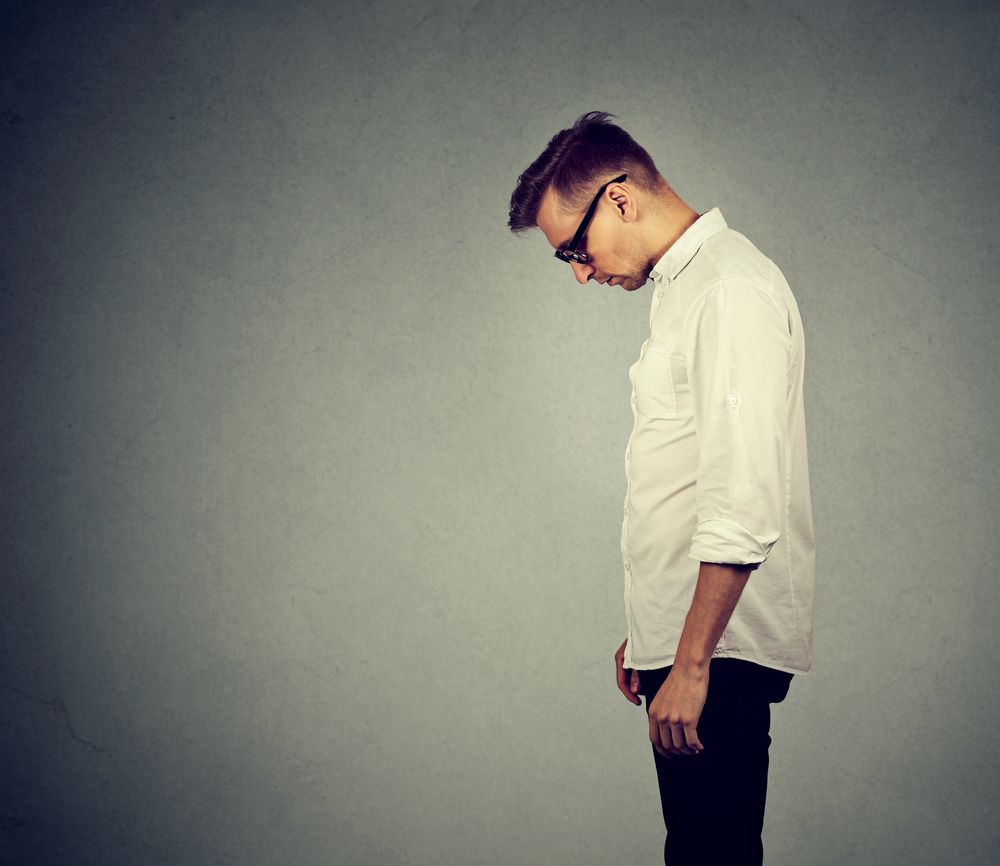 man falsely accused of domestic violence looking down has no energy motivation depressed