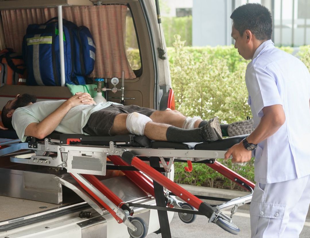 A man is laying on a stretcher in the back of an ambulance.
