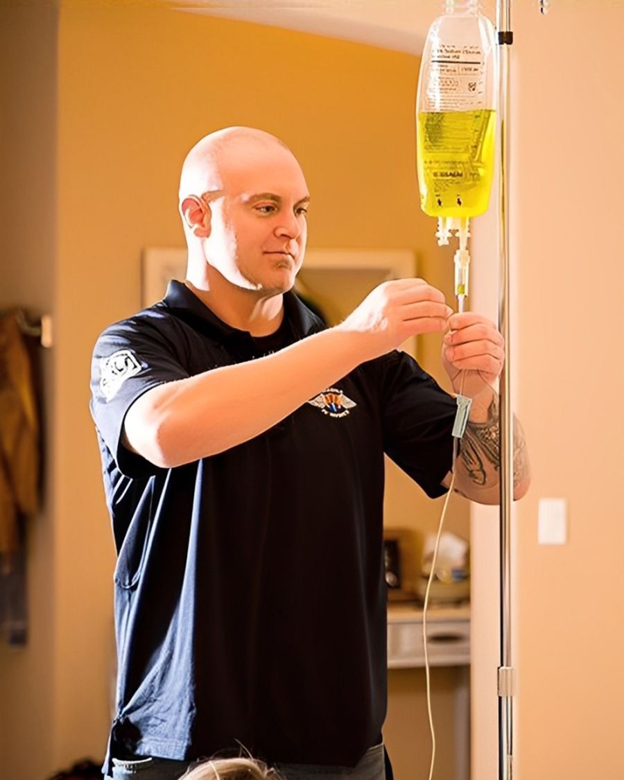 Licensed nurse or medical technician preparing a mobile IV vitamin infusion bag for a client.