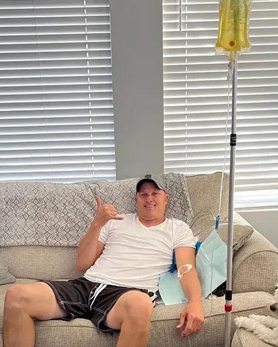 Comfortable mobile IV hydration service for recovery at home, showing a satisfied male client.