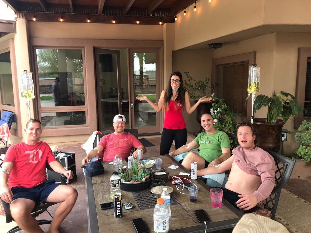 A group of people are sitting around a table on a patio.