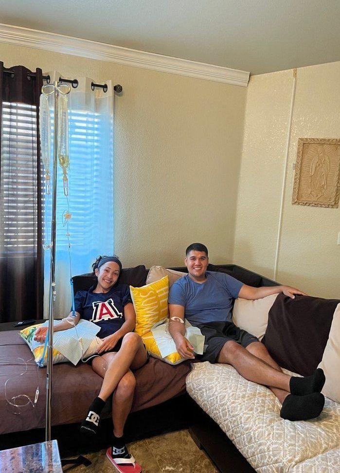 A man and a woman are sitting on a couch in a living room.