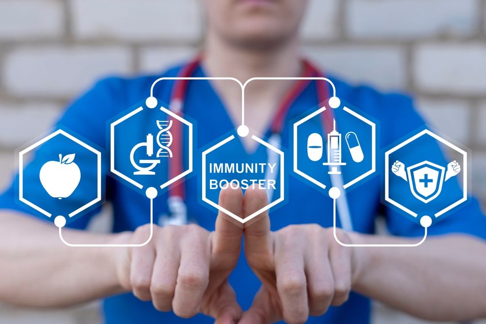 A nurse is holding a screen with icons on it that says `` immunity booster ''.