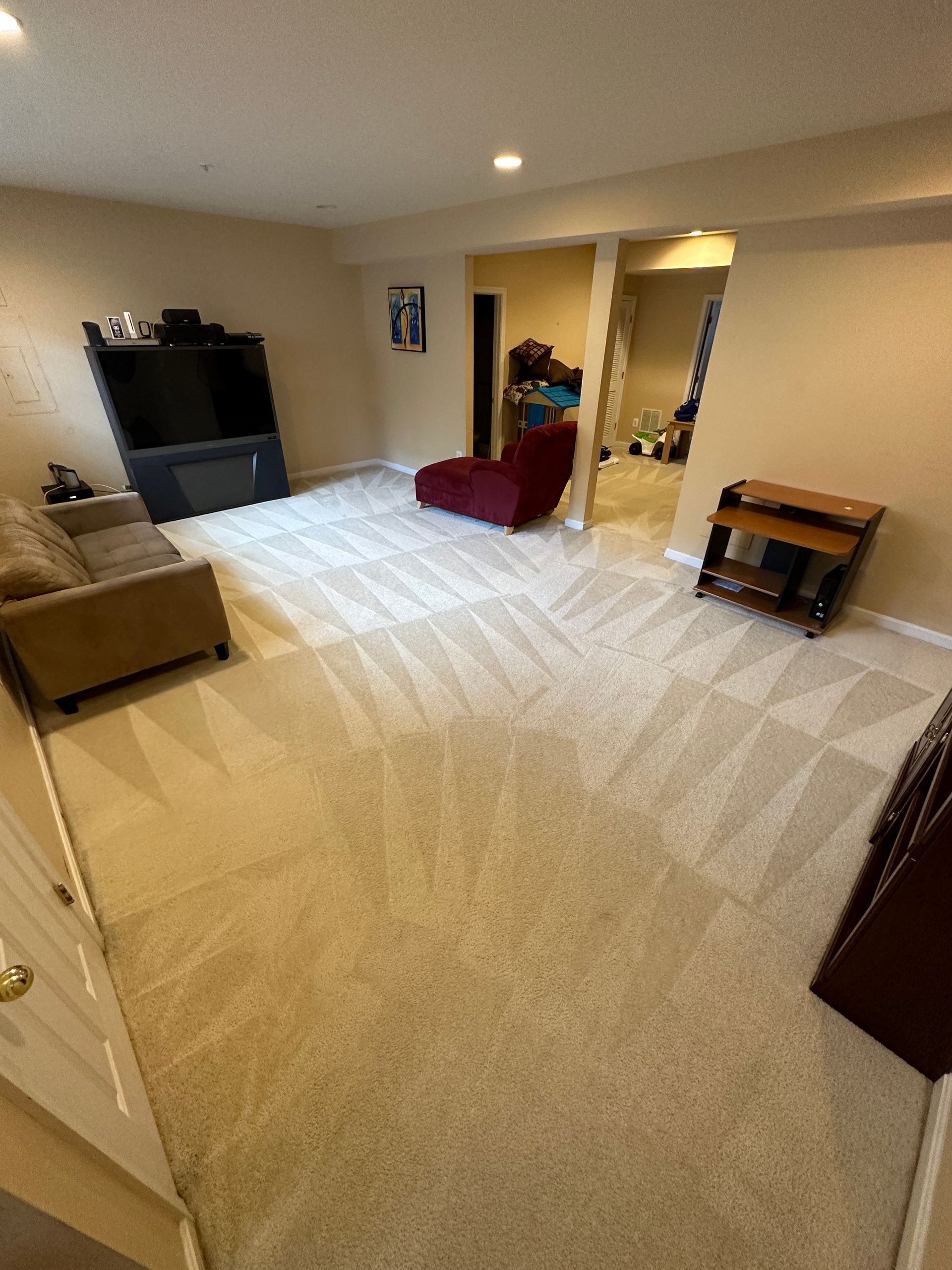 A living room with a couch , chair , and television.