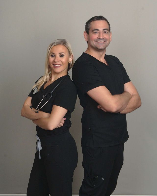 A man and a woman standing back to back with their arms crossed