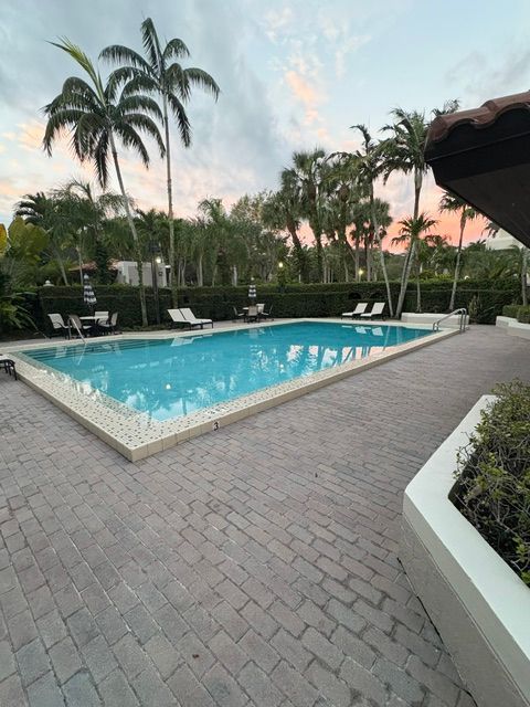 Person's hand using a calculator next to a laptop and paperwork, calculating.