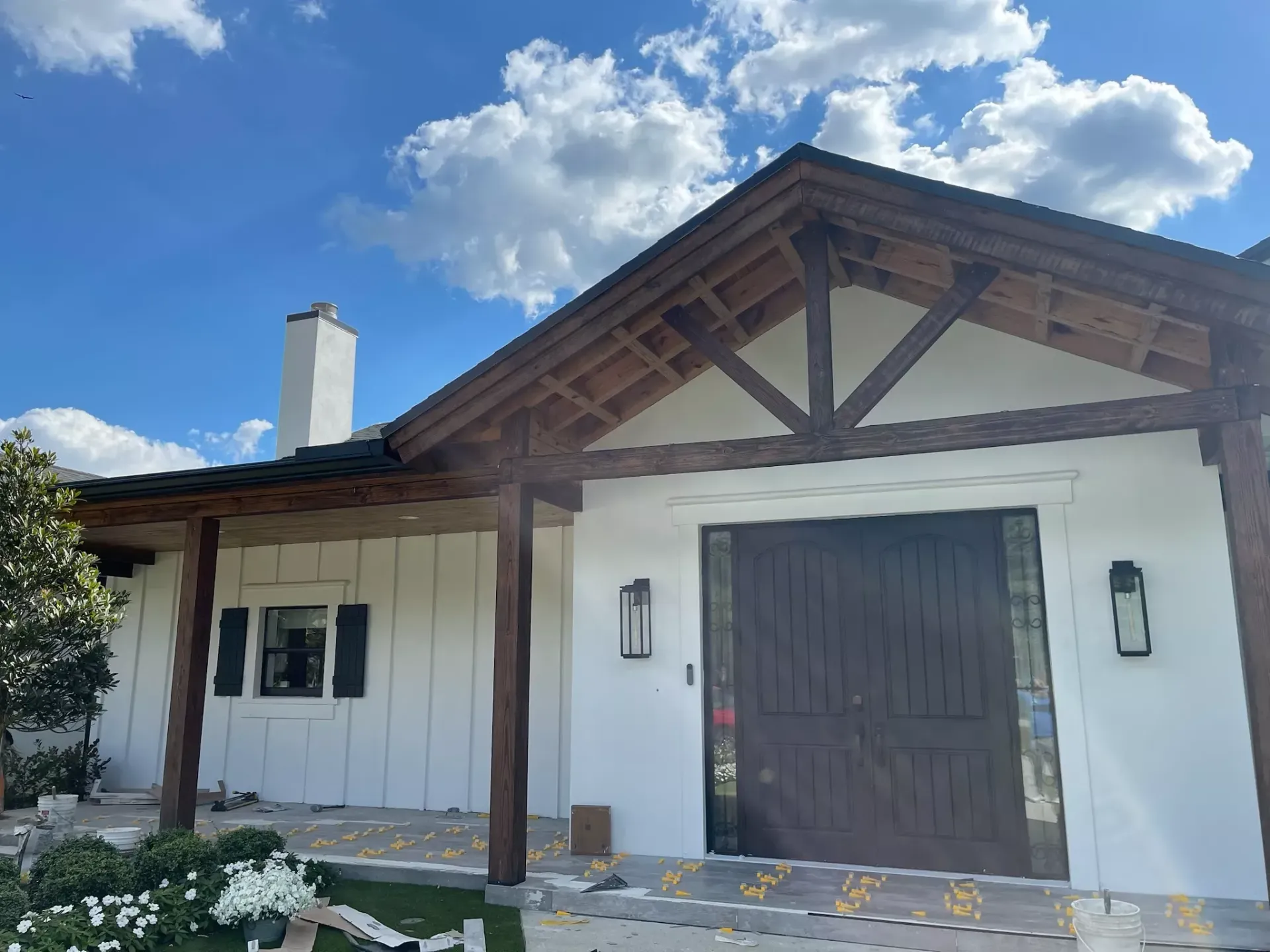 A white house with a wooden roof and a porch.