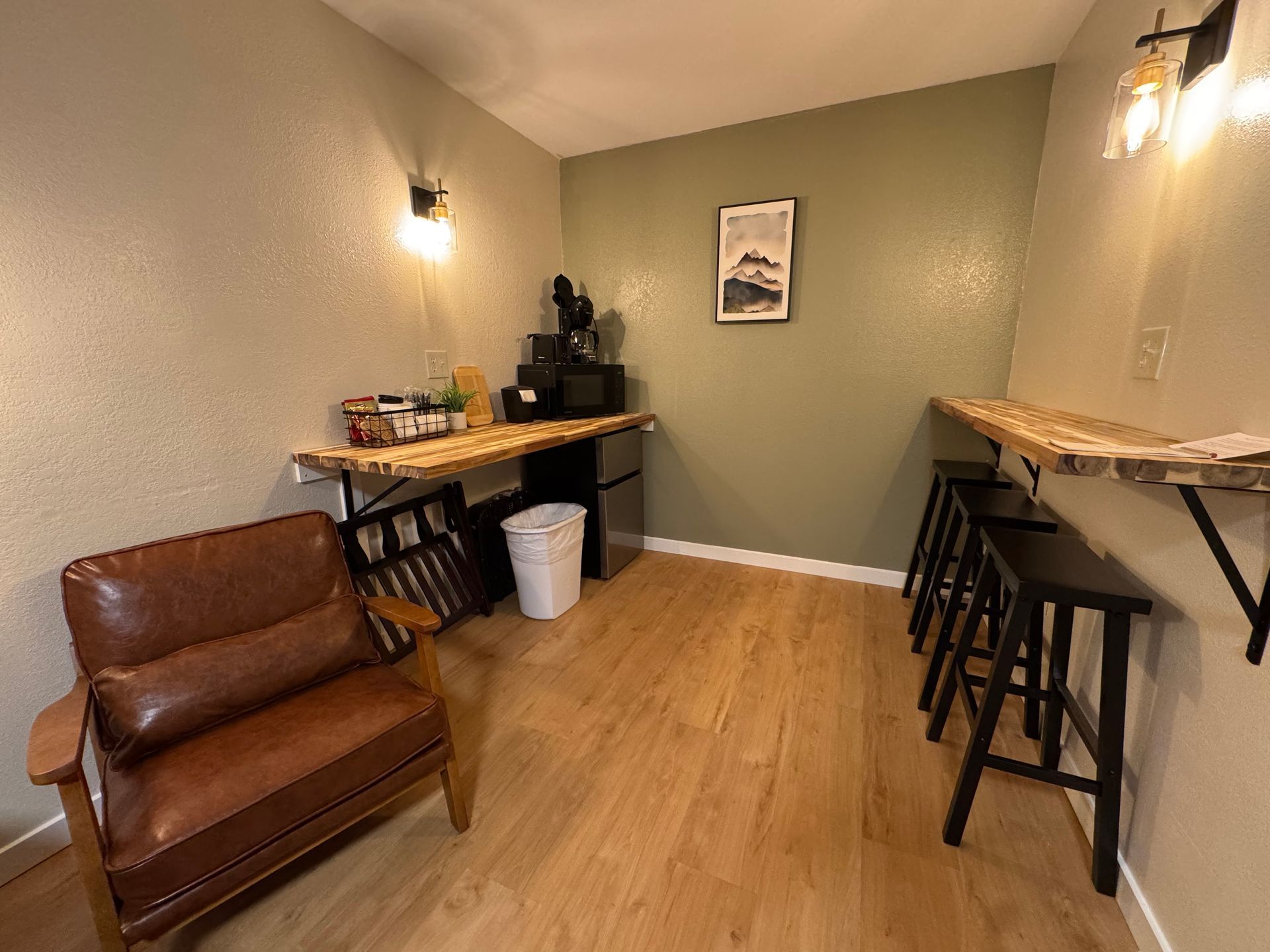 Cozy room with a brown leather chair, bar seating, and a countertop with a microwave and mini fridge.