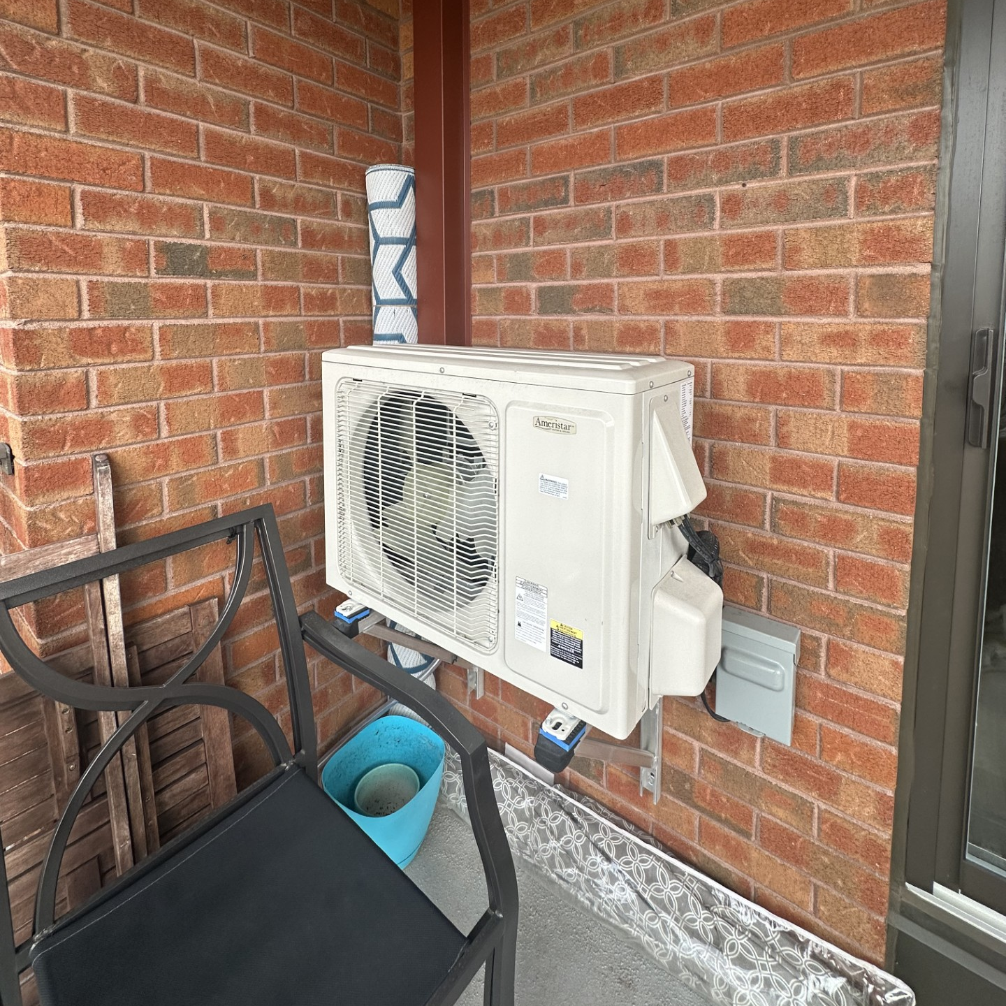 Un climatiseur est monté sur un mur de briques