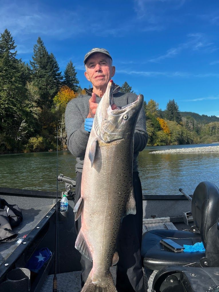 A man is standing on a boat holding a large fish.