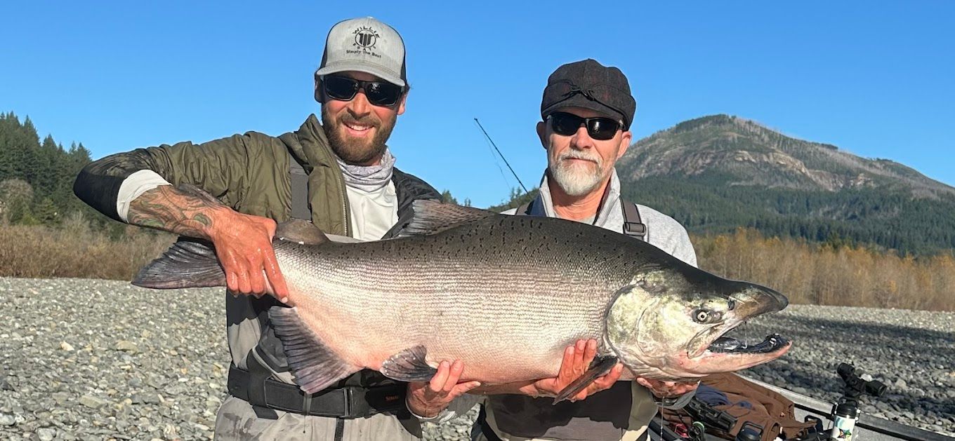 Two men are holding a large fish in their hands.