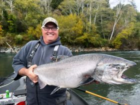 A man in a boat is holding a large fish in his hands.