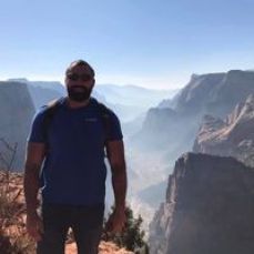 A man is standing on top of a mountain.