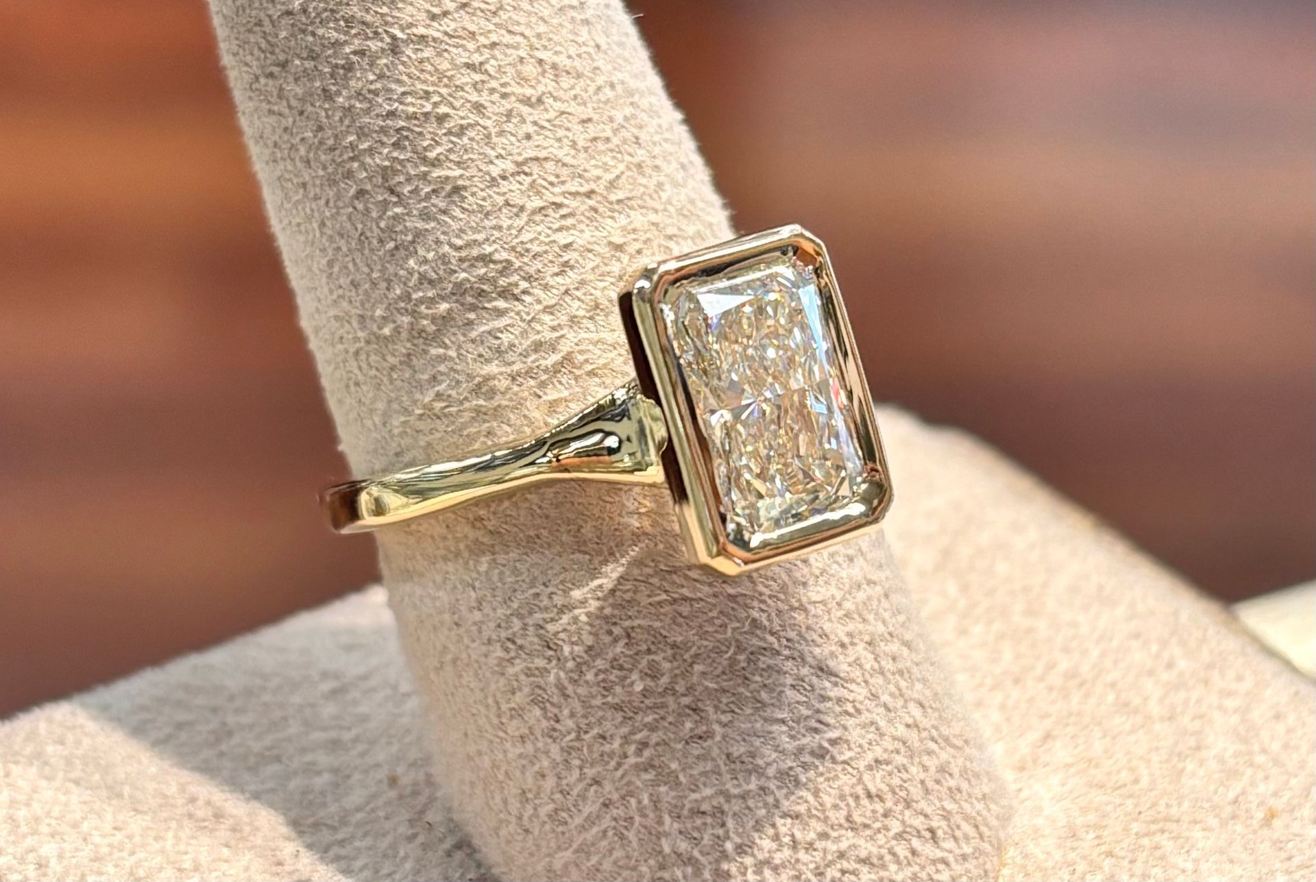 A close up of a diamond ring on a finger.