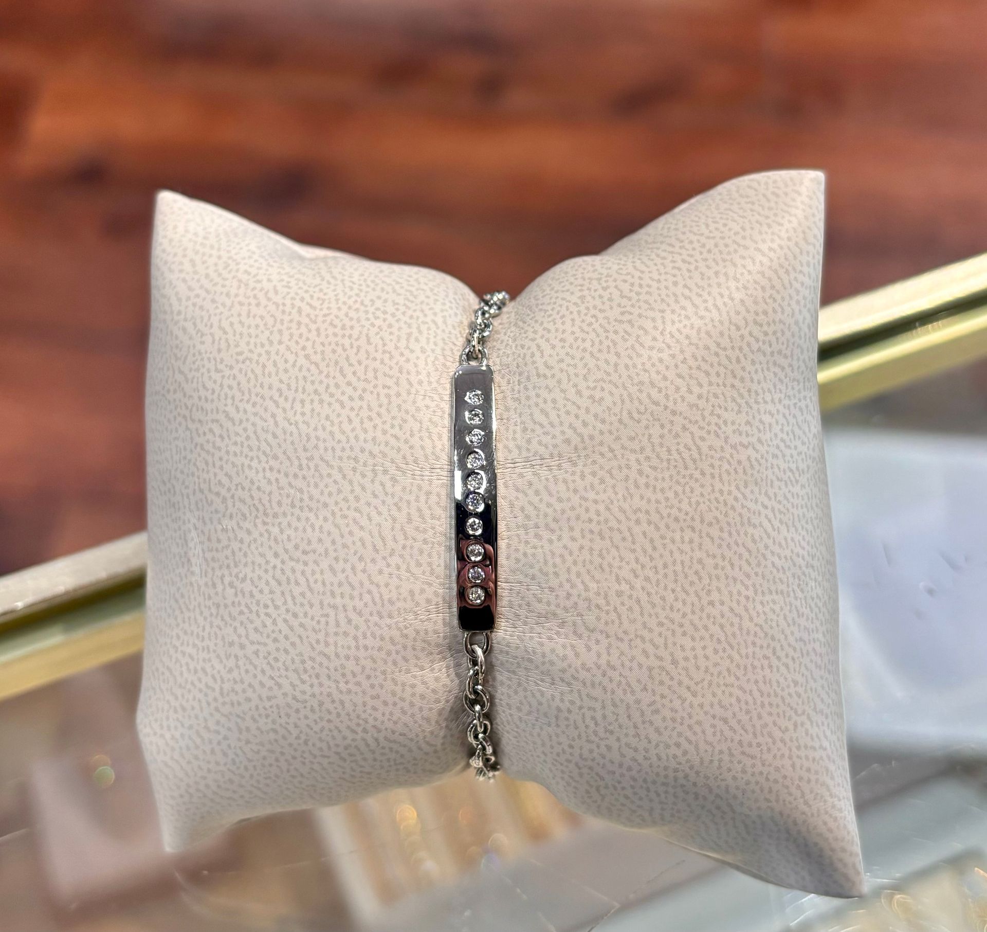 A bracelet is sitting on a white pillow on a table.