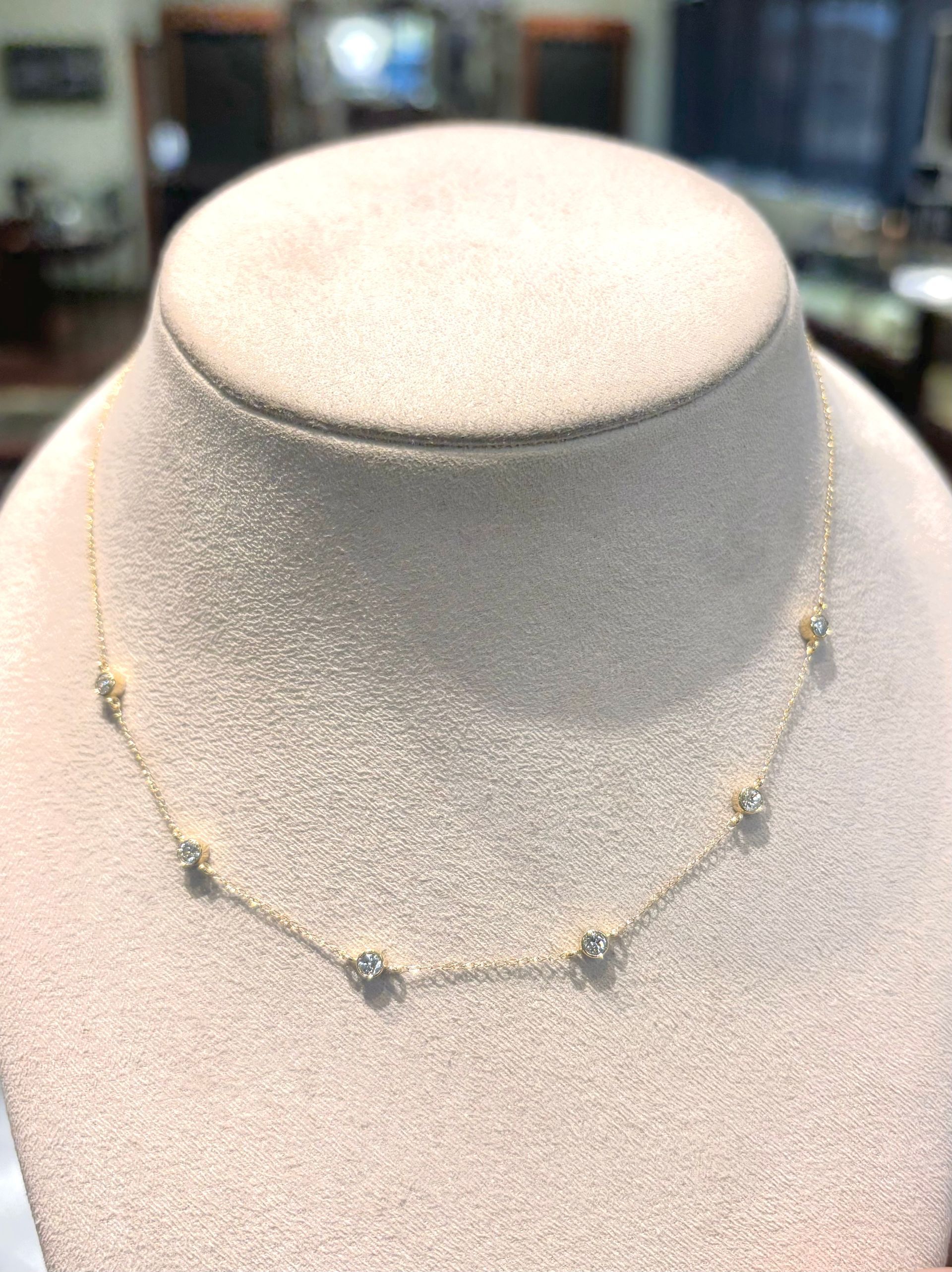 A necklace is on a mannequin in a store.