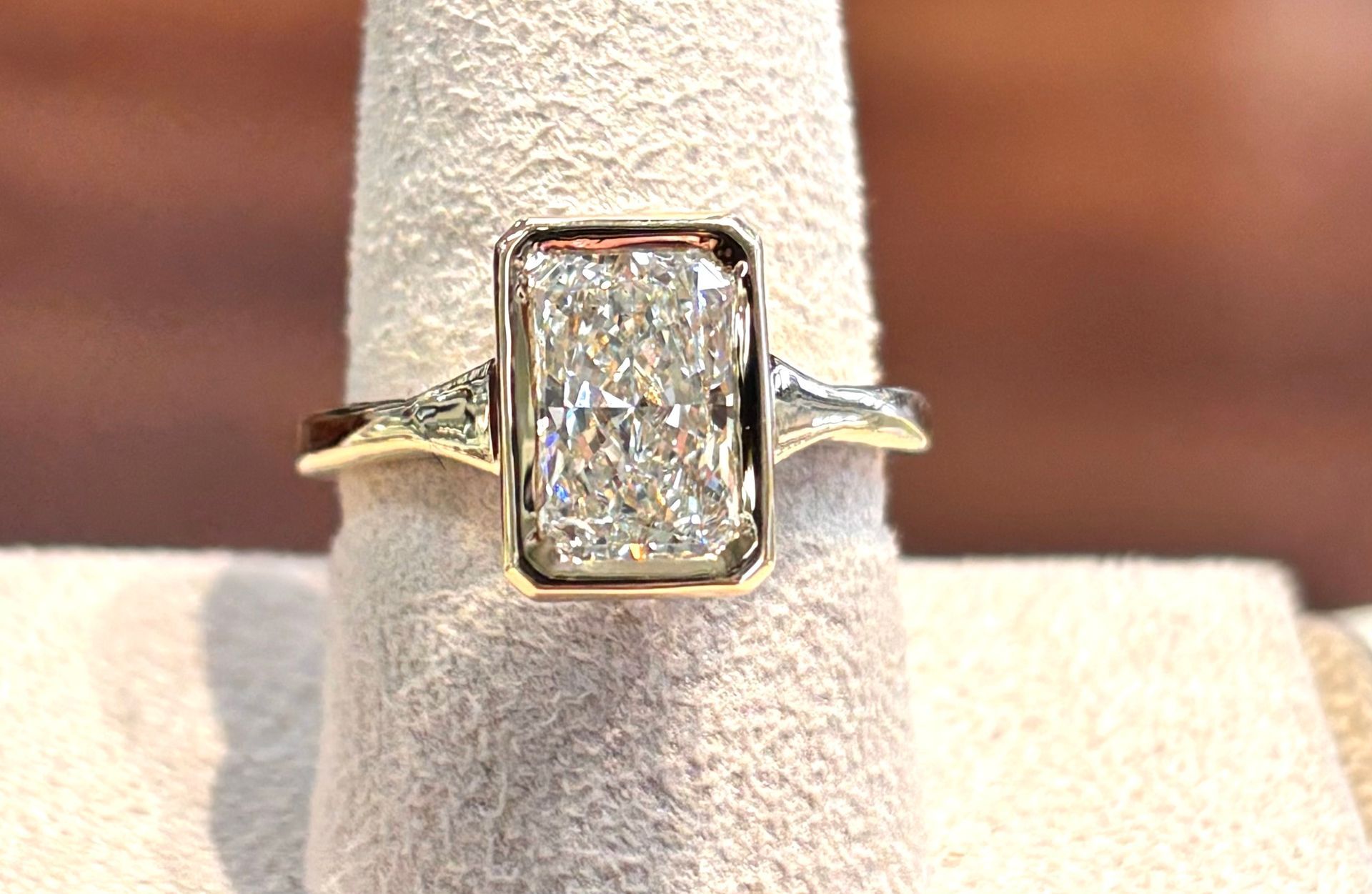 A diamond ring is sitting on a ring holder.