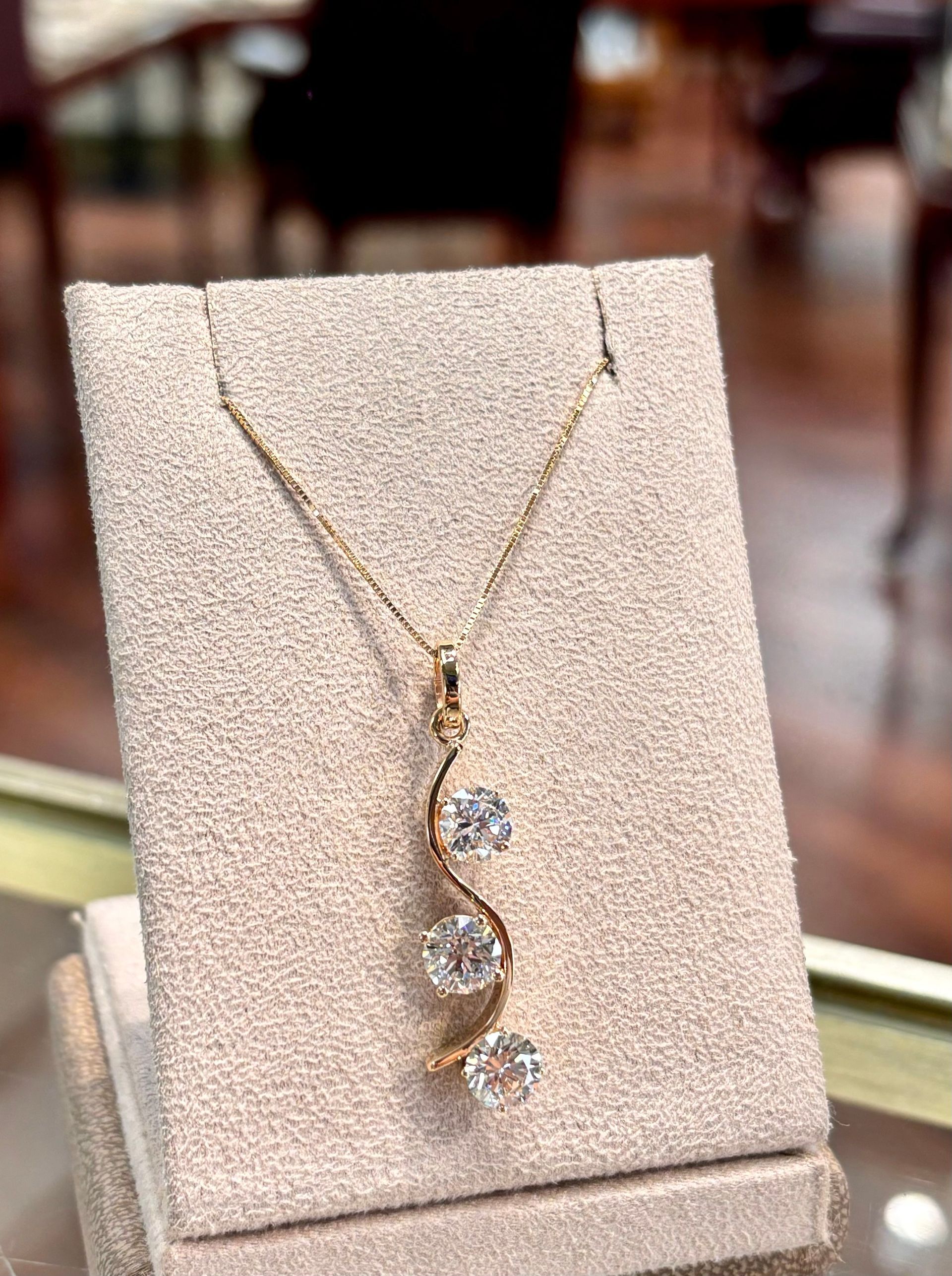 A necklace is sitting on top of a display case on a table.