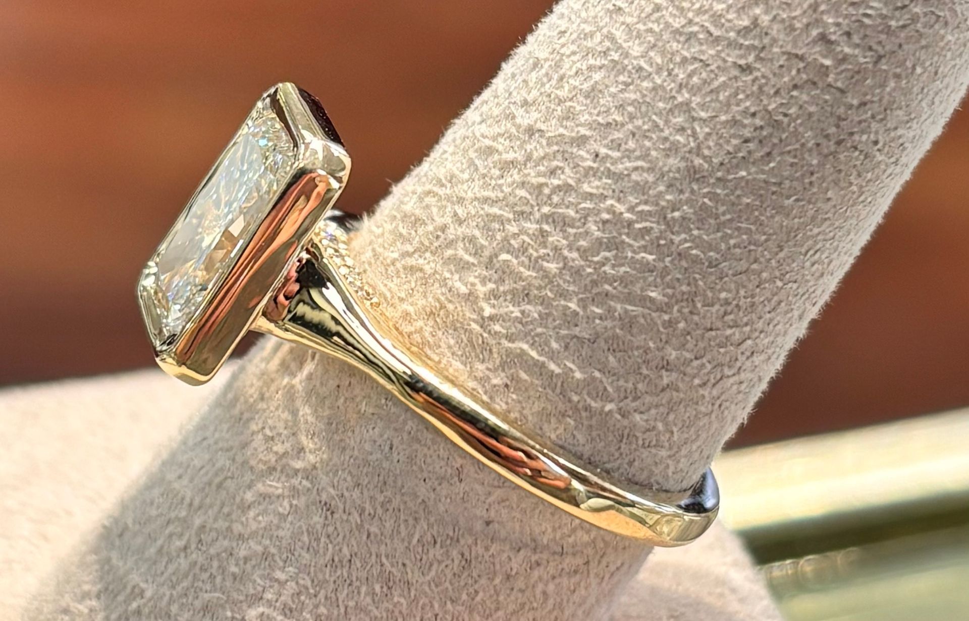 A close up of a diamond ring on a finger