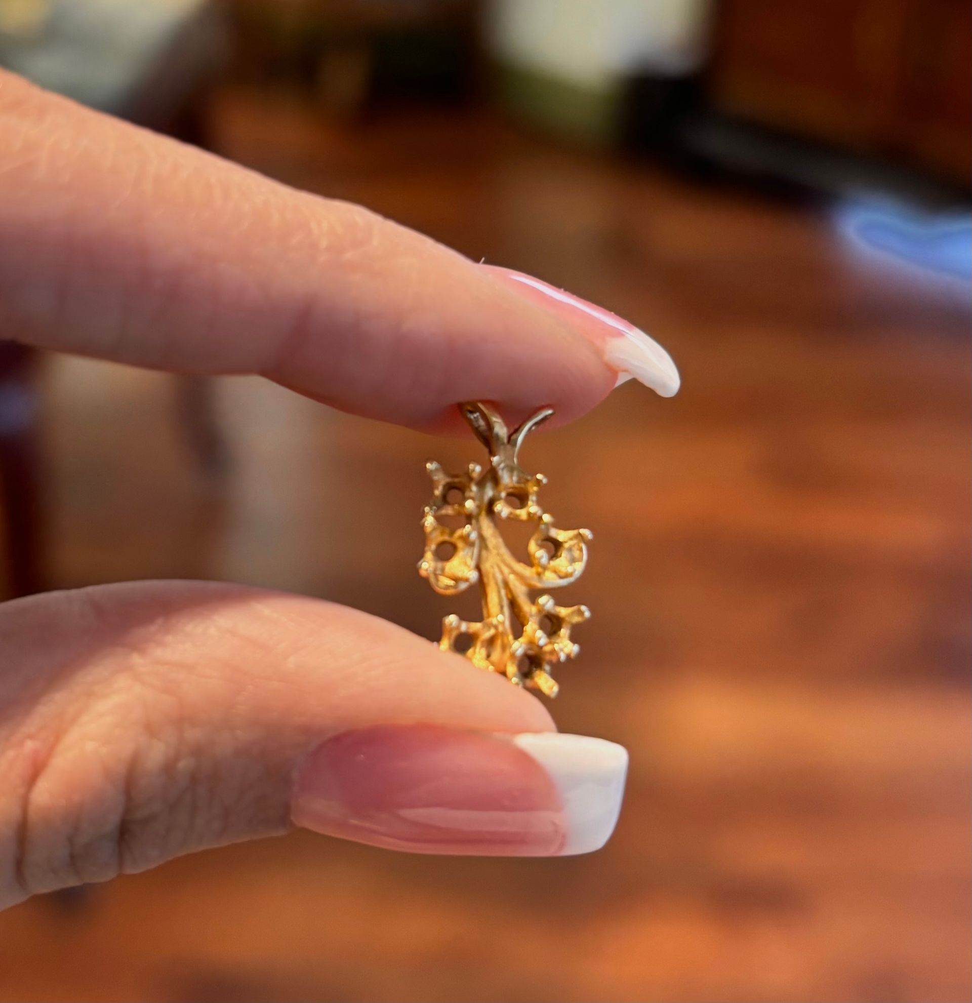A woman holds a small gold pendant in her hand