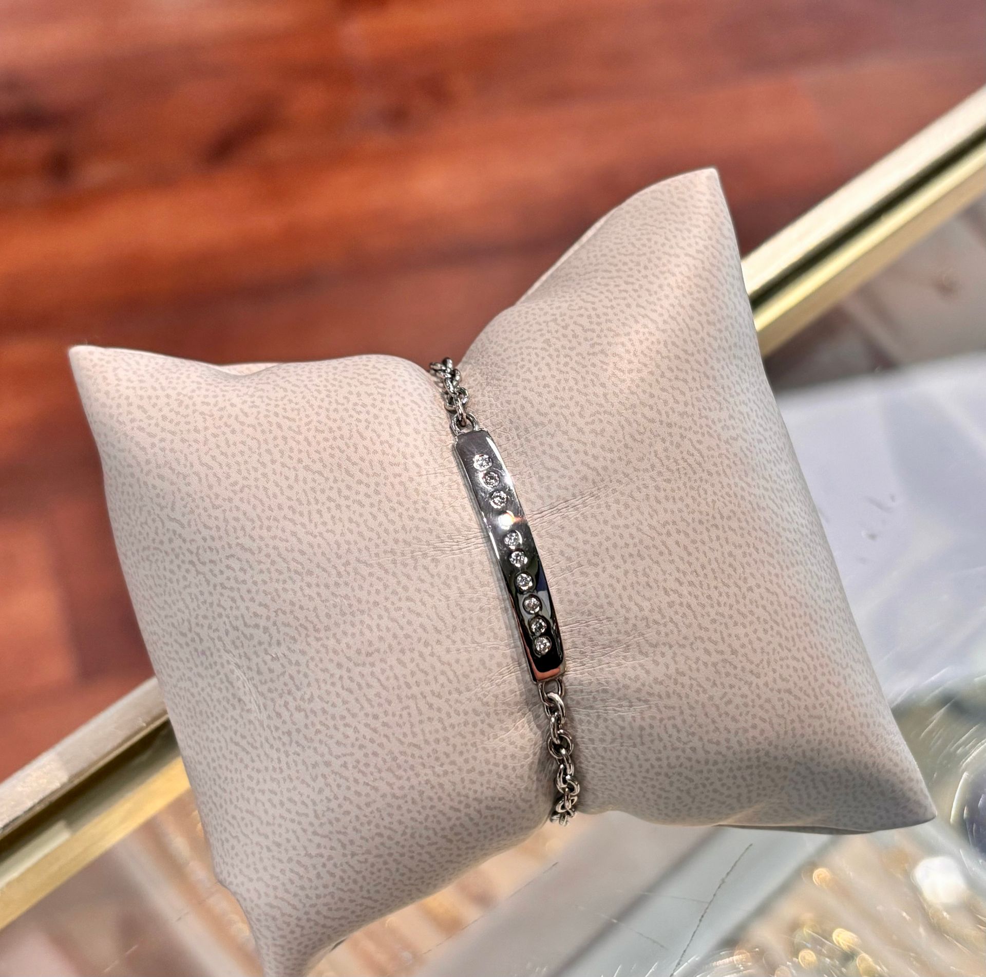A white pillow with a bracelet on it