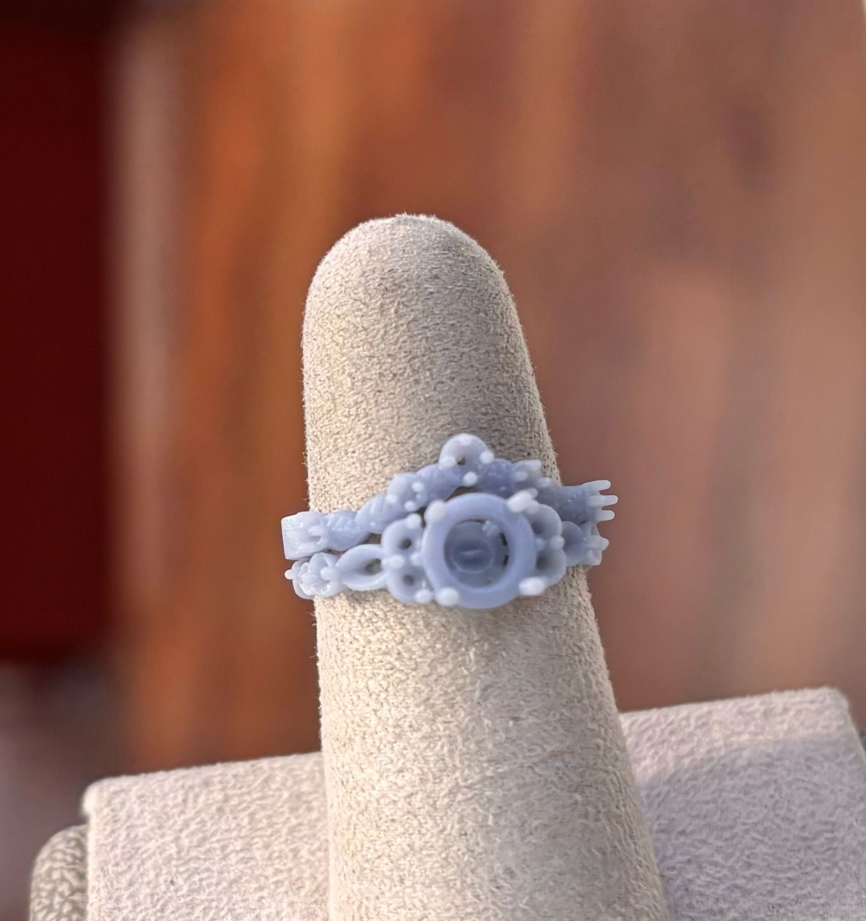 A close up of a ring on a finger on a ring holder.