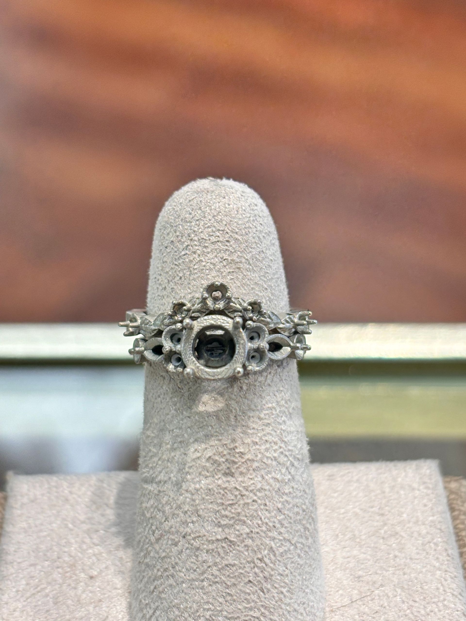 A ring is sitting on a ring holder on a table.