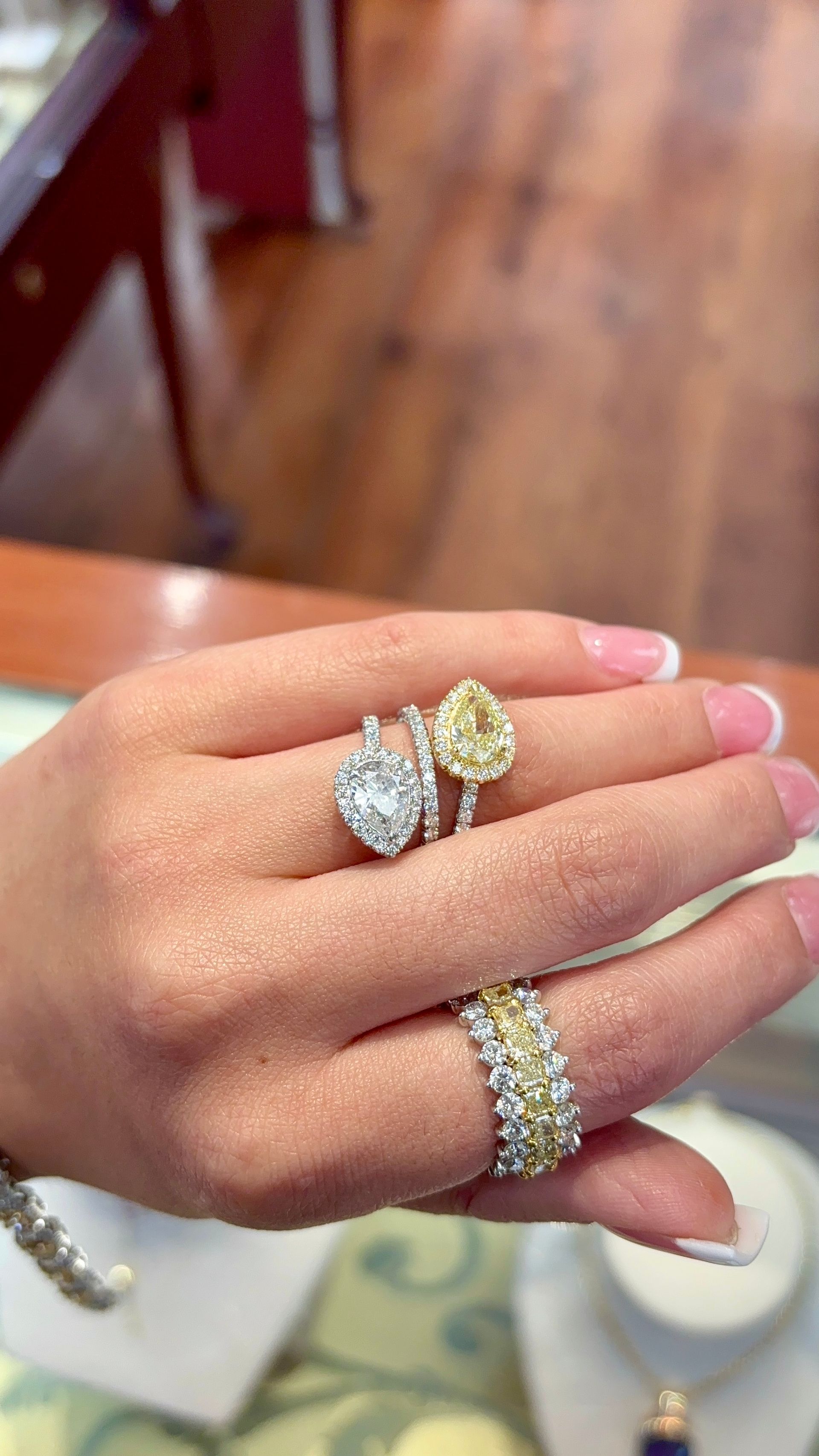 A woman is holding three rings on her finger.