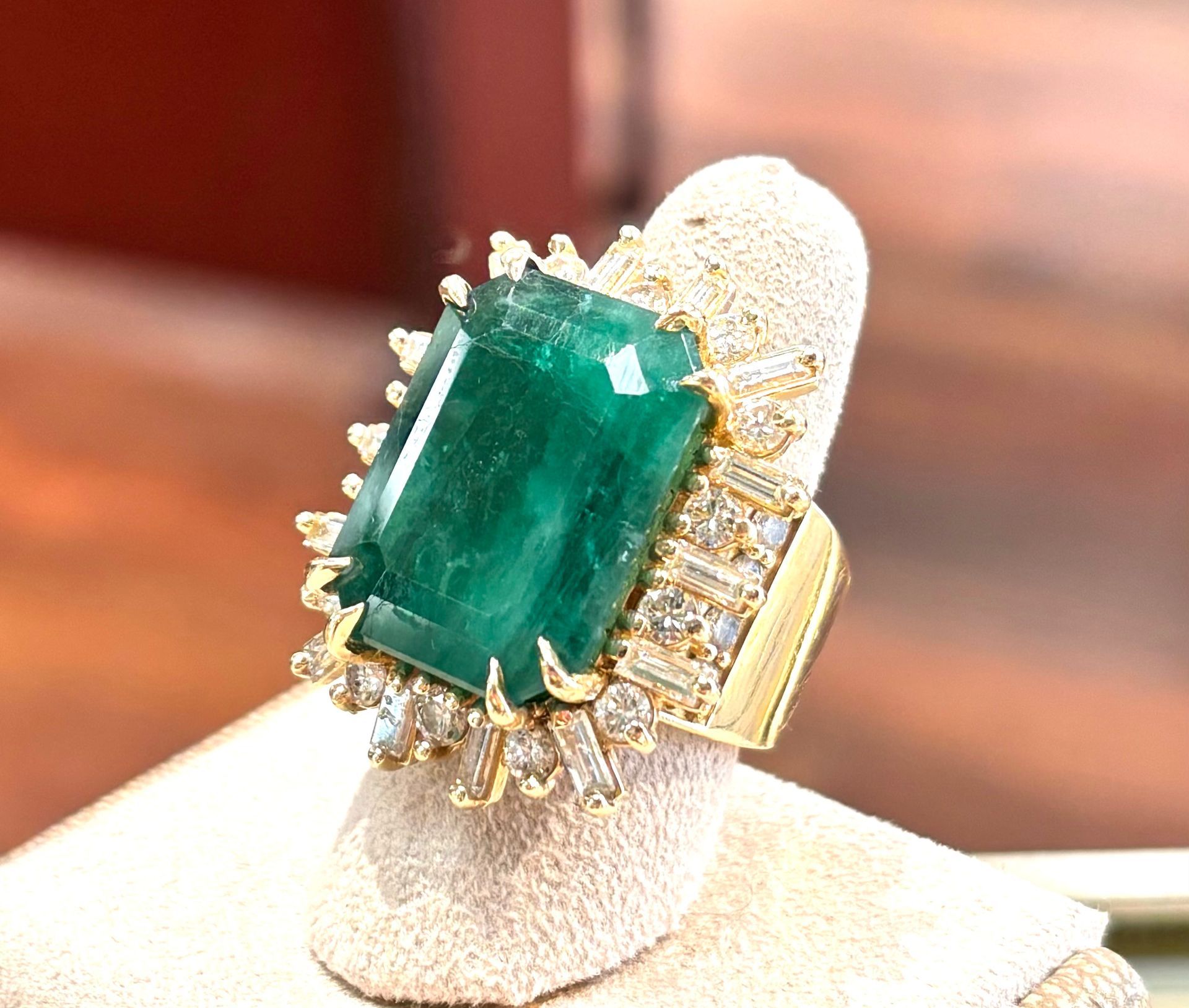 A gold ring with a large emerald and diamonds