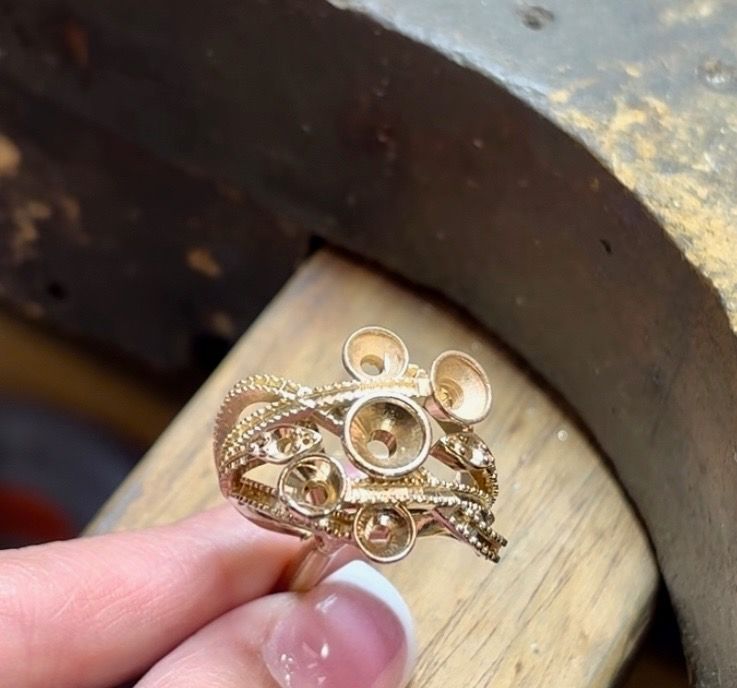 A person is holding a gold ring in their hand