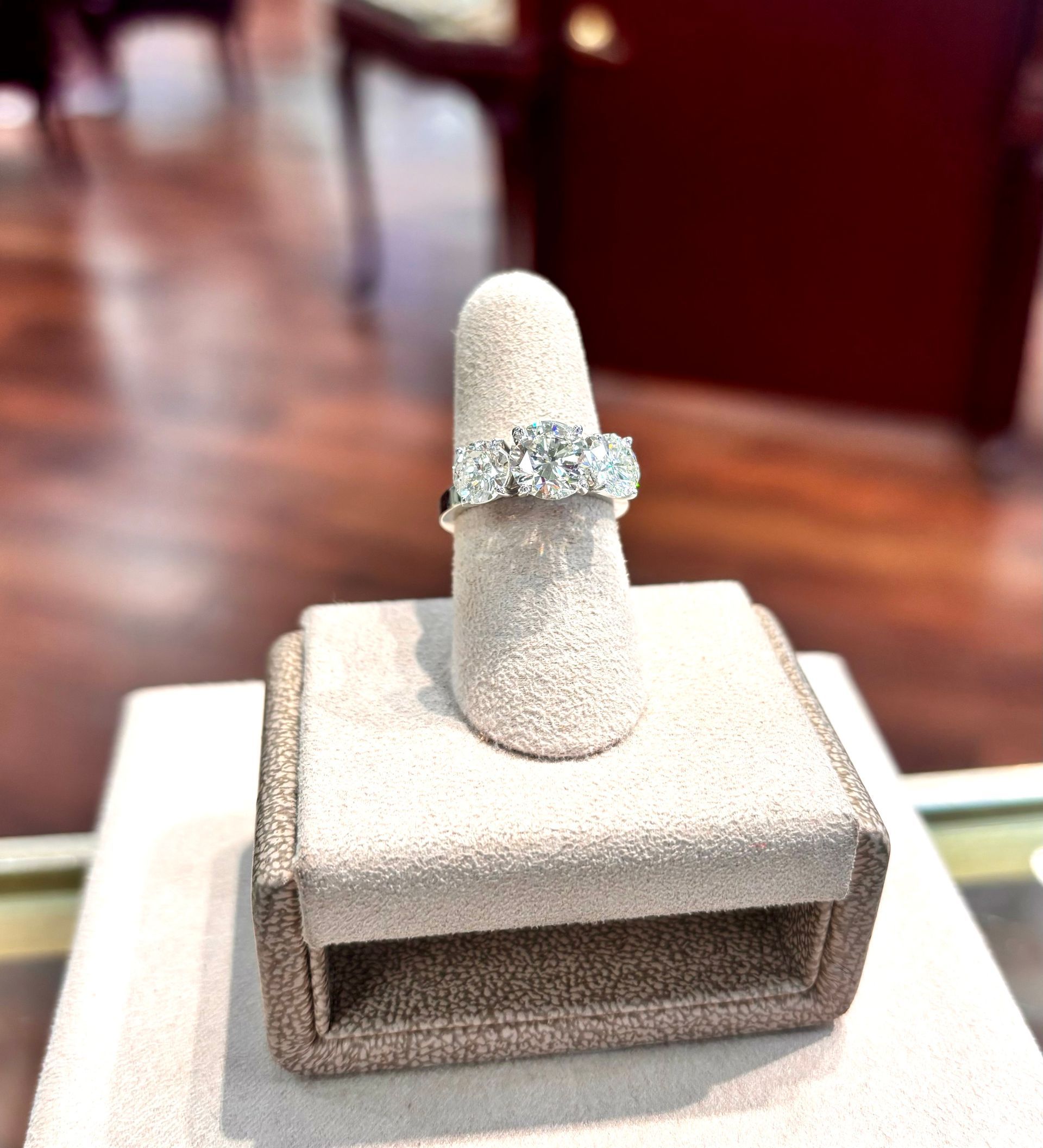 A diamond ring is on display on a ring holder