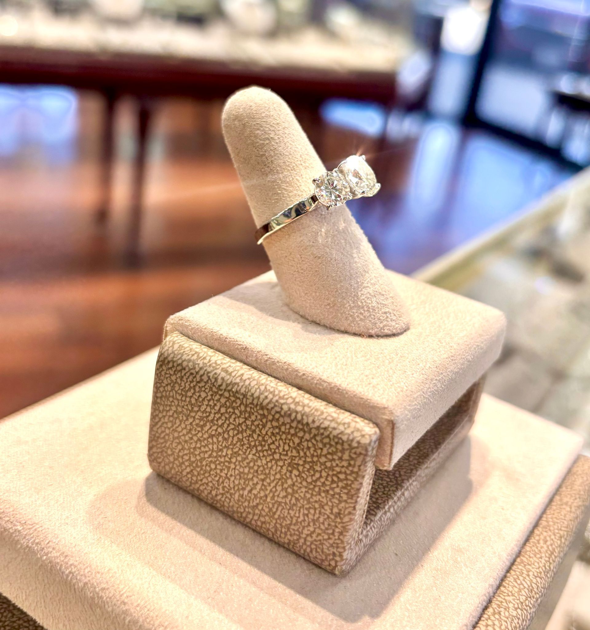 A diamond ring is sitting on top of a ring holder.