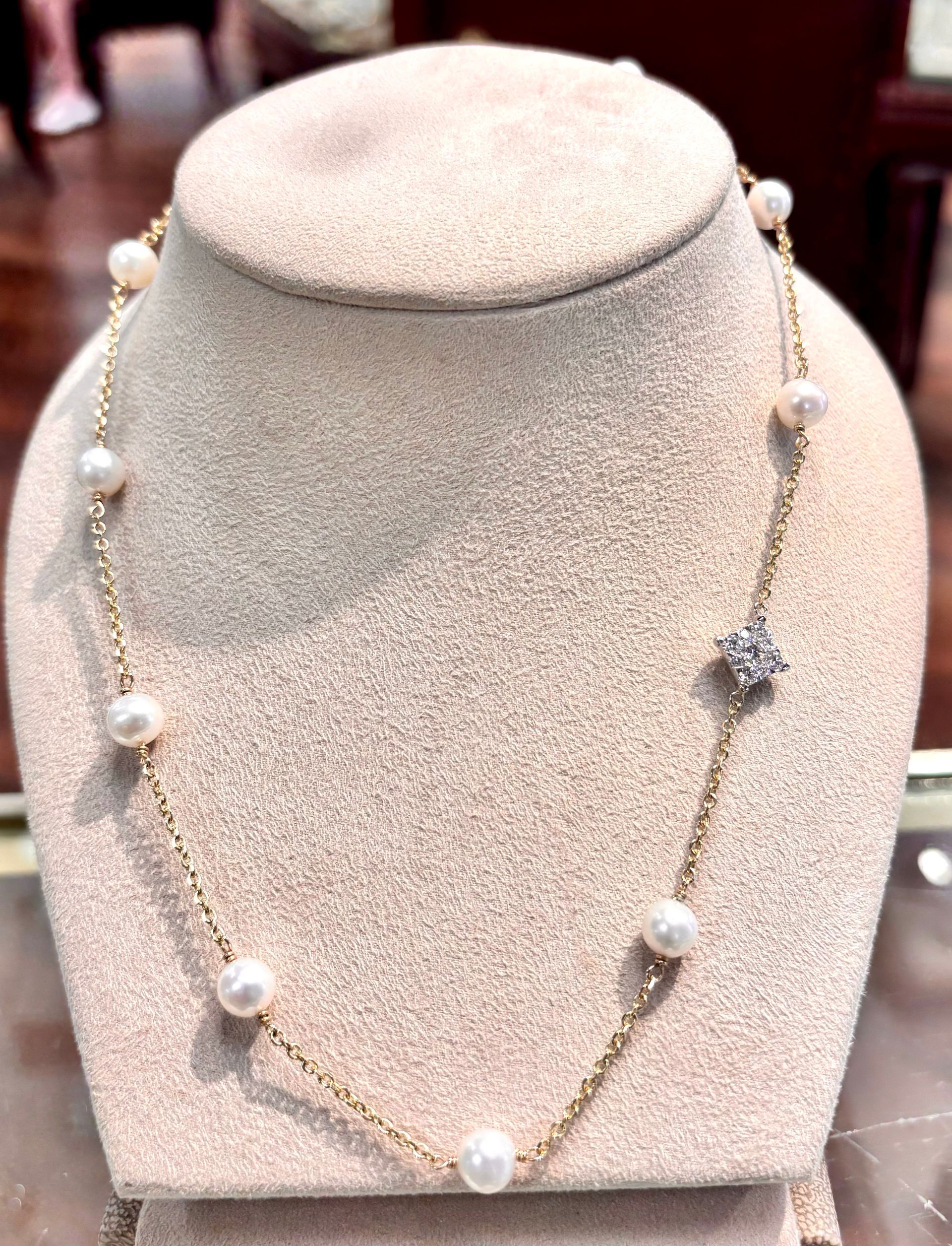 A necklace with pearls and diamonds is on a mannequin.
