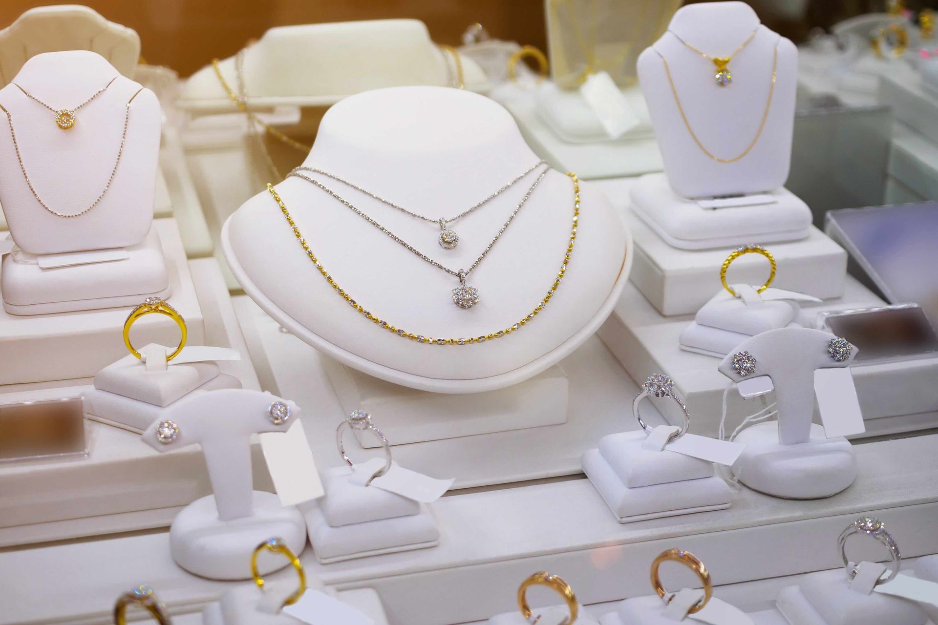 A display of necklaces and rings on mannequins in a jewelry store.