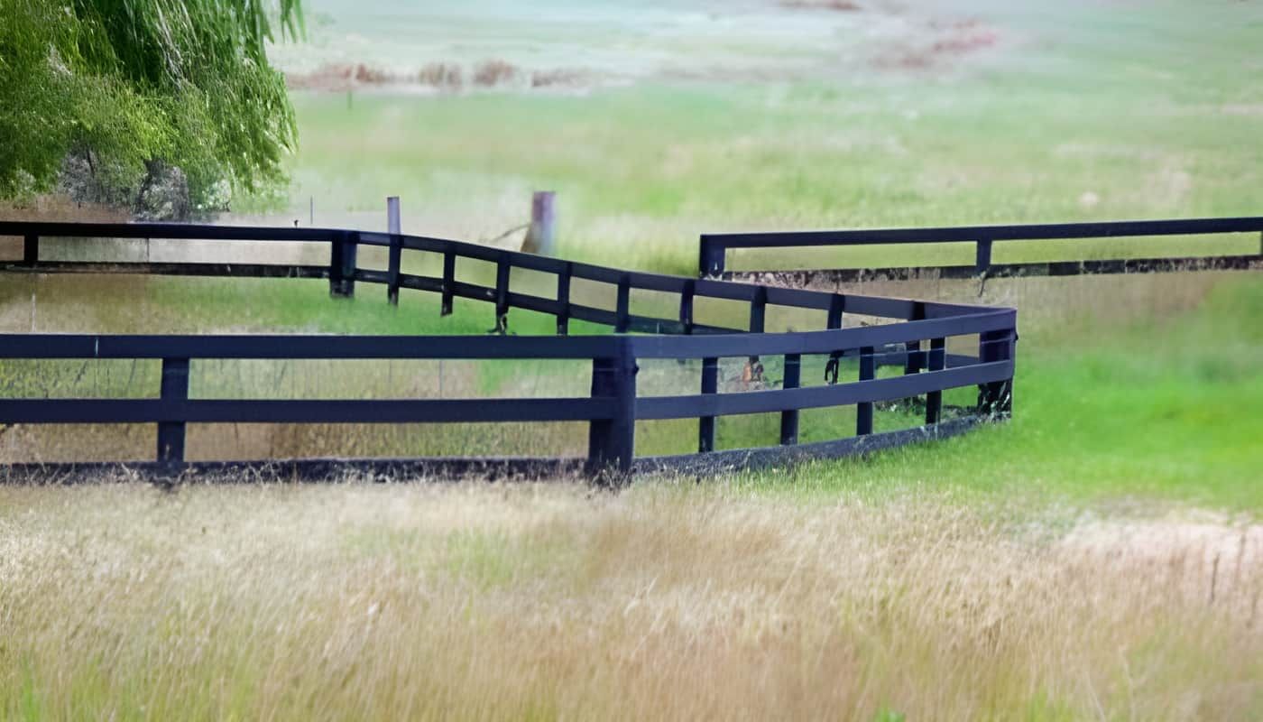 A Black Wooden Fence Surrounds a Grassy Field — Osborne Fencing in Bundanoon, NSW