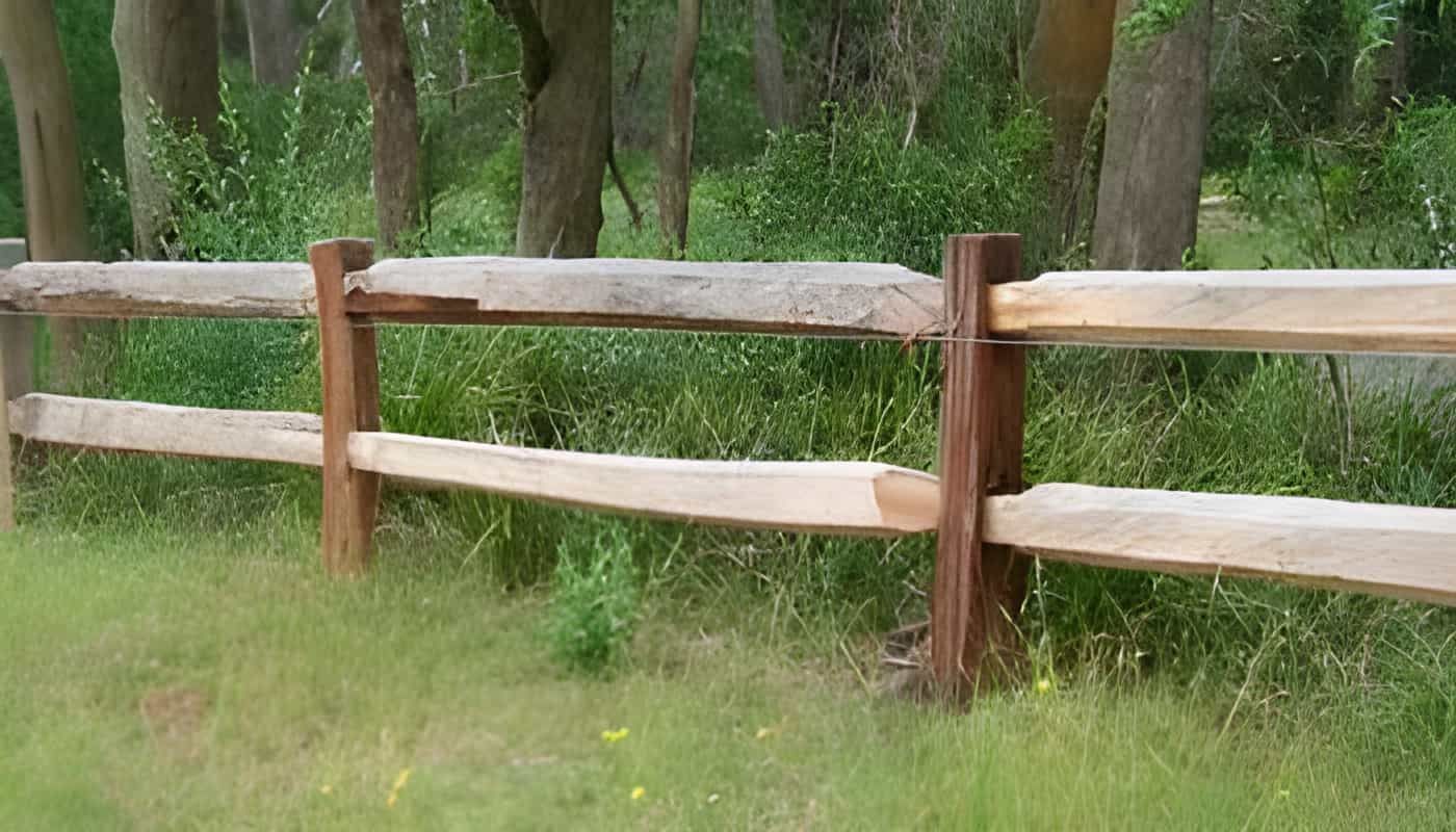 A Wooden Fence is in the Middle of a Grassy Field — Osborne Fencing in Bundanoon, NSW