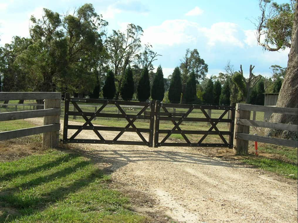 A Dirt Road With a Wooden Fence and a Gate — Osborne Fencing in Exeter, NSW