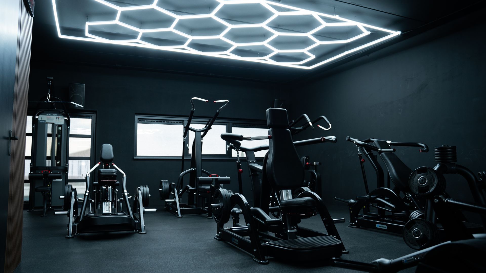 In een sportschool staat een rij hometrainers opgesteld.