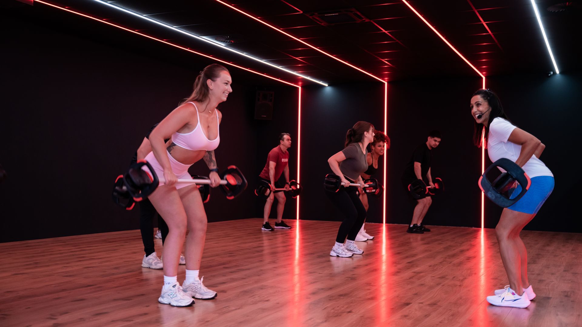 Een vrouw doet een plank met een halter in een sportschool.