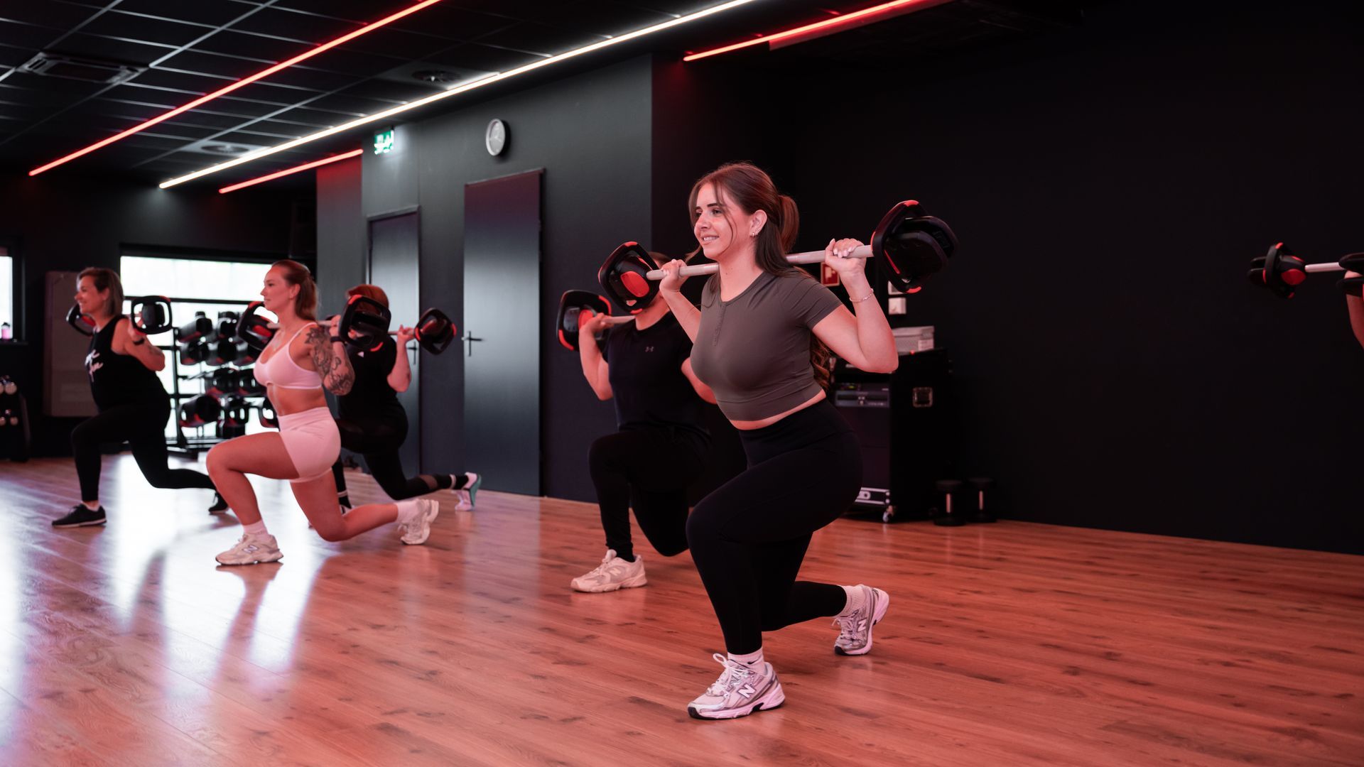 Een vrouw doet push-ups met een halter in een sportschool.