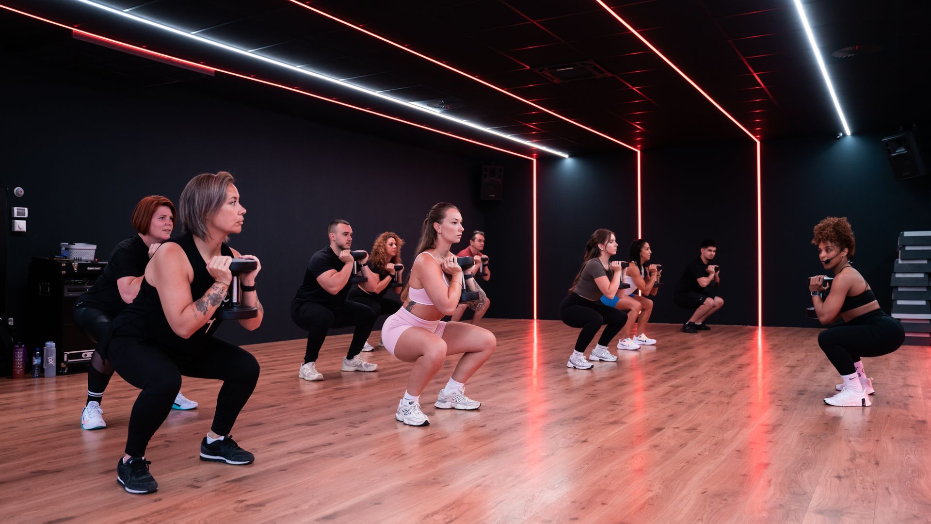 Een vrouw doet push-ups met een halter in een sportschool.