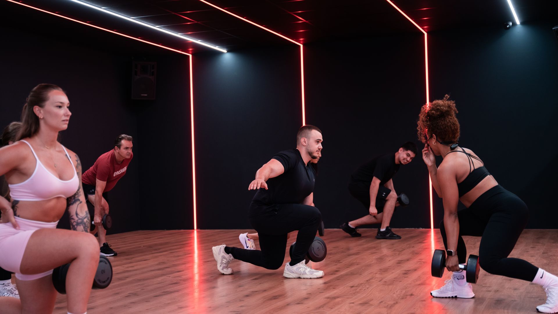Een vrouw doet push-ups met een halter in een sportschool.